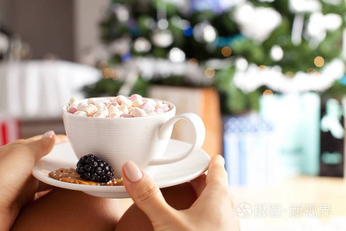 女性手里拿着一杯热巧克力和果汁软糖照片-正版商用图片0w5t6g-摄图新