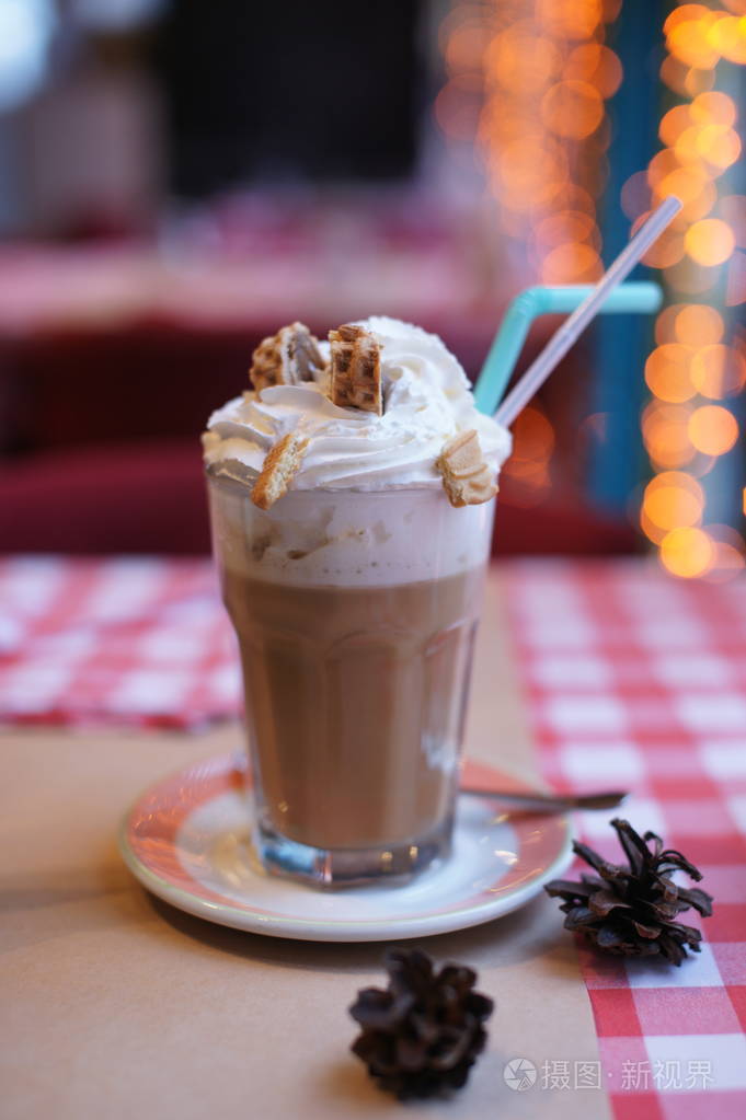 大杯的咖啡加奶油和晶片在餐厅的桌子上