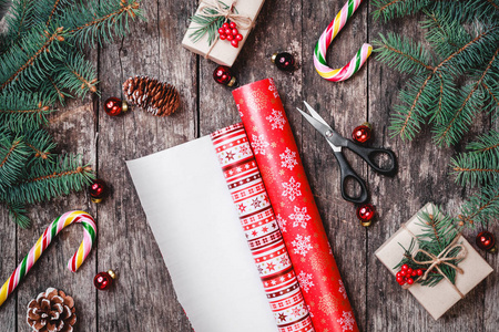 与圣诞包装 冷杉的枝条 礼品 松果 木制背景上的红色装饰圣诞组成。圣诞节和新年快乐卡。平躺，顶视图