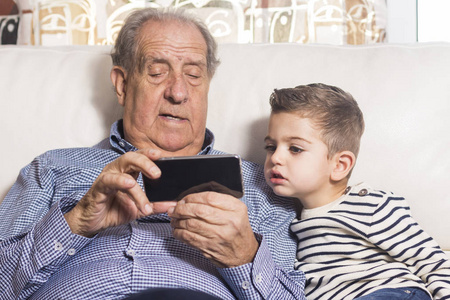 祖父和孙子看一部智能手机
