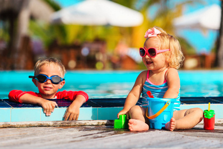 小男孩和女孩在游泳池在海滩玩
