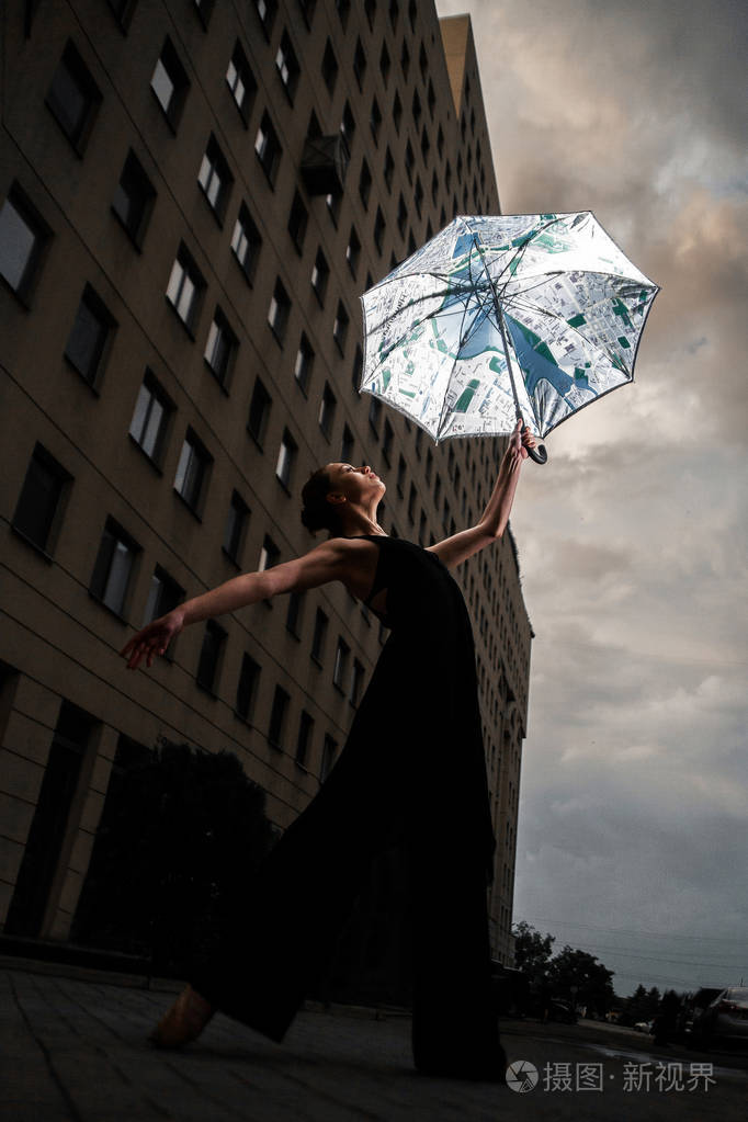 芭蕾舞女演员在城市街道上布依族, 背景天空上的伞
