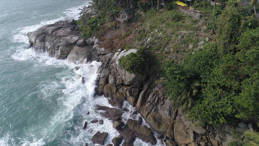 空中顶视图的海浪打在普吉岛的海滩上的岩石