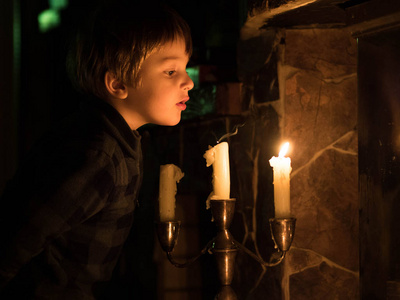 小可爱的孩子吹灭蜡烛的烛台.