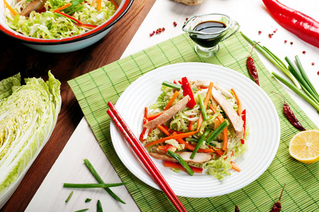 明亮的多汁饮食凉拌卷心菜 红辣椒 胡萝卜 葱 和烤鸡在白板上。东部，中国菜。简单的自制沙拉饮食