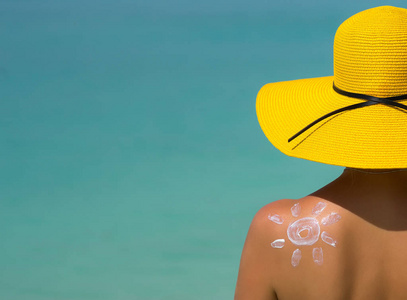 太阳形防晒霜在海滩上的女人