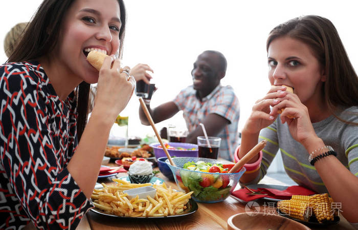 一群人在一起时坐在木桌吃饭