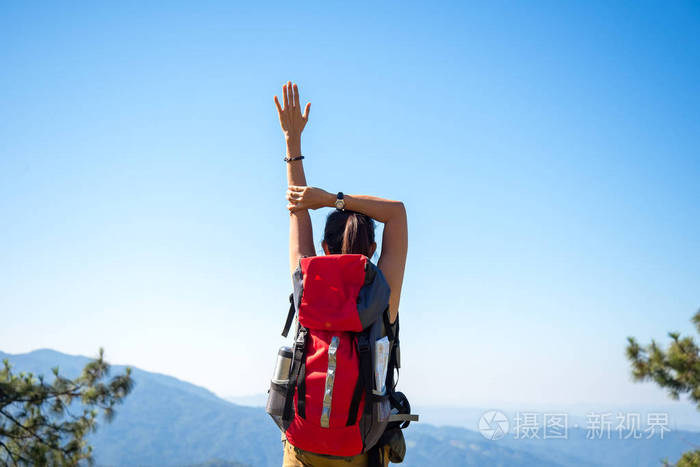 徒步旅行者女人感觉胜利面临在山上