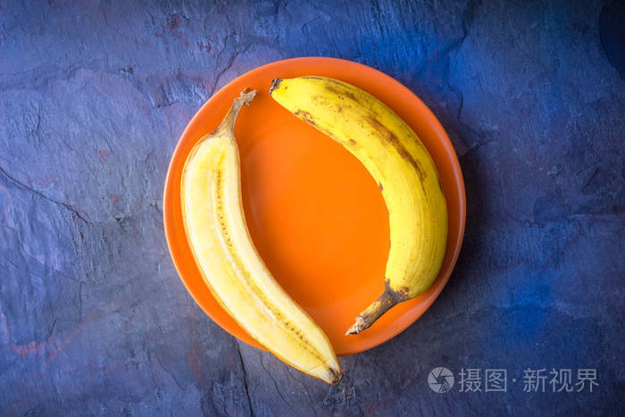 半根香蕉躺在一个橙色的盘子上