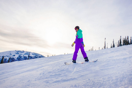 在 Sheregesh 山的一个滑雪的女孩。一个年轻的女孩站在山顶 Sheregesh。会议是黎明。时尚的白种人滑雪