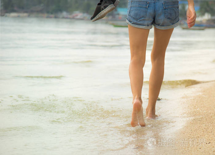 漂亮的腿的一个漂亮的女孩在水中行走