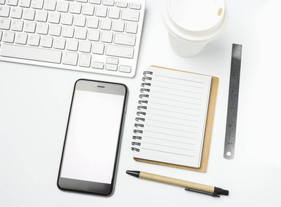 办公室工作区与键盘记事本咖啡的杯和白色背景上的智能手机