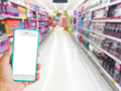 左手牵着绿色手机超市与模糊背景，在线购物的概念