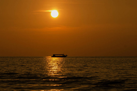 湖上，一条船在地平线上的日落