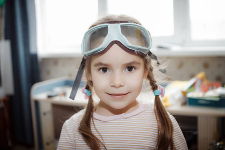小女孩在家里玩的飞行员眼镜