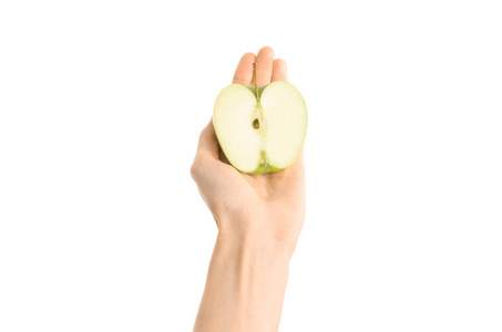 健康的饮食和饮食主题 人类的手，握著孤立在工作室里，第一人称视角的白色背景上的半青苹果