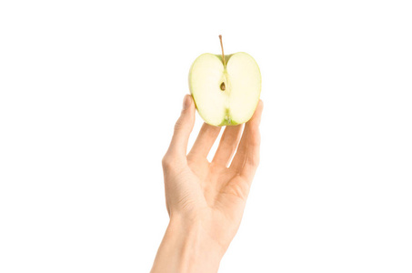 健康的饮食和饮食主题 人类的手，握著孤立在工作室里，第一人称视角的白色背景上的半青苹果