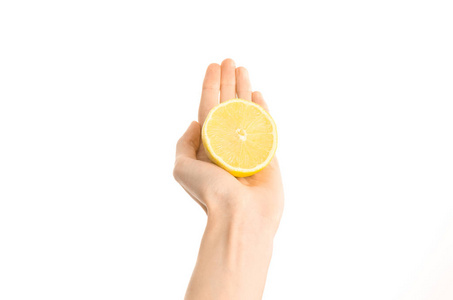 健康的饮食和饮食主题 人类的手，一半孤立在工作室里，第一人称视角的白色背景上的柠檬