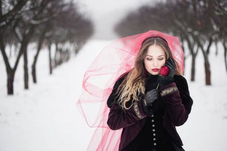 女孩在红色的面纱，在冬天的雪