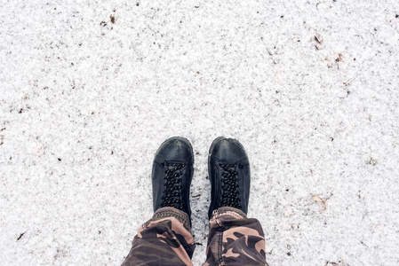 男子脚皮鞋站在从上面的雪