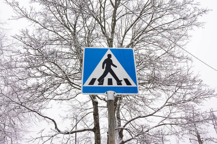 冬季天空背景上的人行横道路标