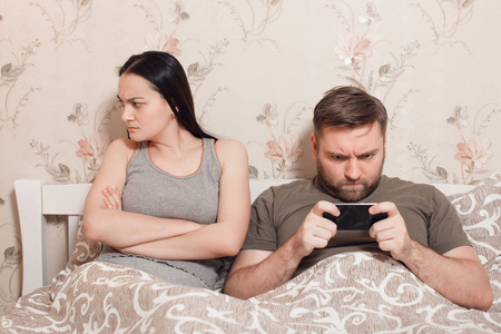 男人在床上的女人用智能手机
