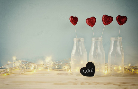 闪闪发光的心在木制的桌子上的玻璃花瓶