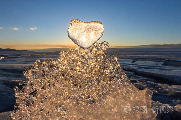 通过纹理烟盒上冰冷的心的夕阳照耀的太阳