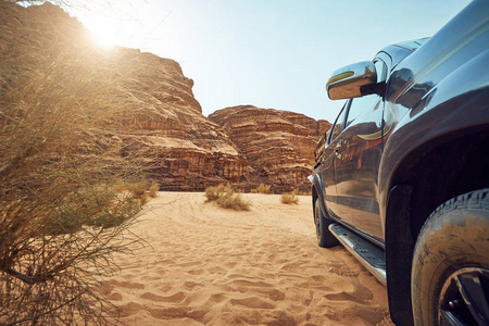 阳光明媚的岩石景观和大汽车在瓦迪鲁姆沙漠中沙特阿拉伯
