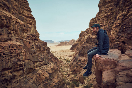 坐在红色岩石在瓦迪鲁姆沙漠在约旦很认真的人