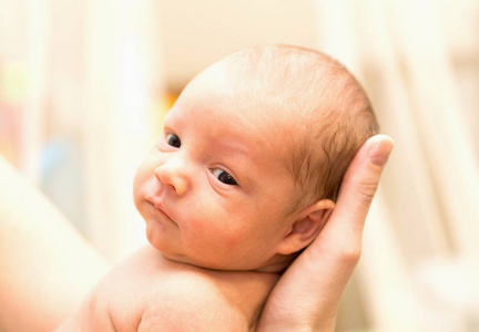 可爱的刚出生的婴儿在母亲的手中。股票照片