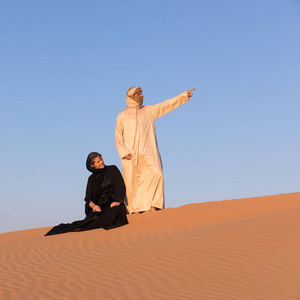 几个穿着阿拉伯传统的服装在阿联酋的迪拜沙漠照片