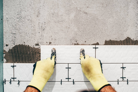 工业的工人，在浴室的墙壁上安装小陶瓷墙地砖的勤杂工