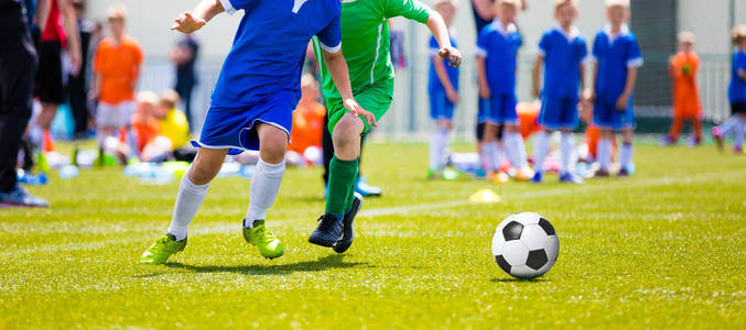 孩子们玩足球游戏。年轻的男孩在草地上踢足球足球比赛。孩子们的足球比赛。跑步 踢踢球的年轻球员
