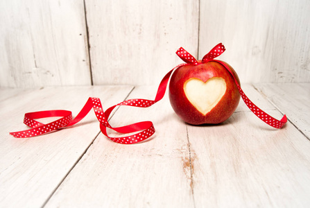 白色木头上的红色苹果礼物