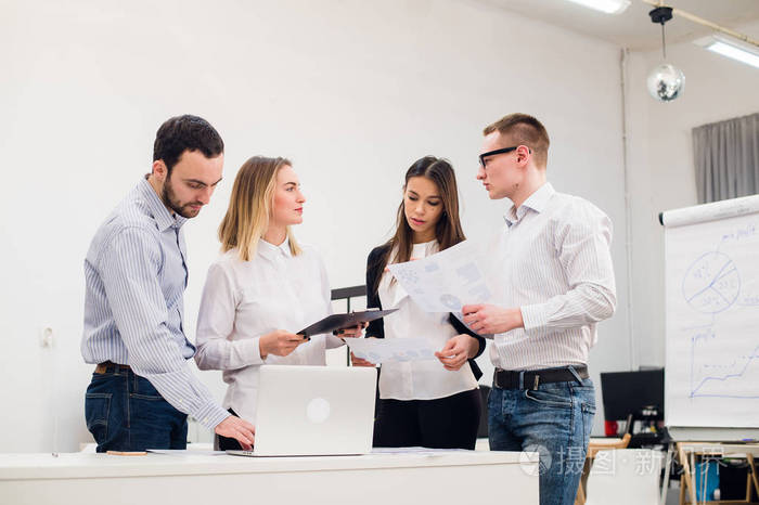 年轻人与同事在一次会议讨论的市场研究在会议室里看