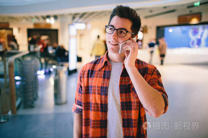 男人坚持商场背景的智能手机