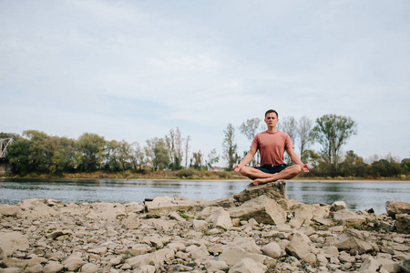 男人练瑜伽在河岸边