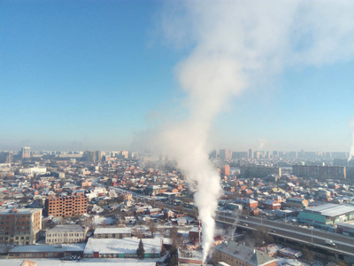 冬季小镇。 寒冷的晴天在城市里。 街道上的雪和锅炉里的烟雾升起。 霜和太阳是美好的一天。