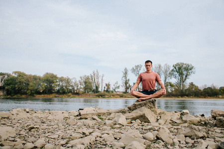 男人练瑜伽在河岸边