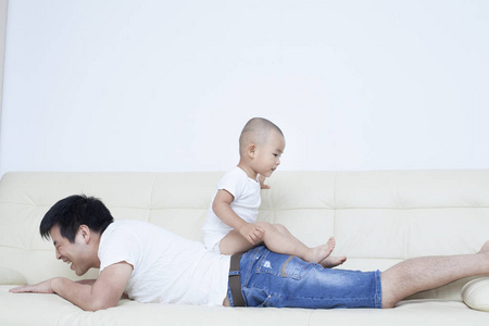 中国父亲和儿子在沙发上玩