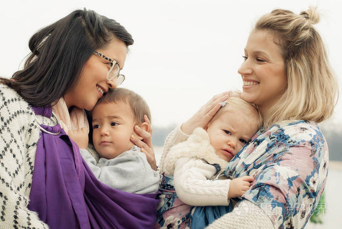 两个母亲与婴儿在婴儿背带翘曲