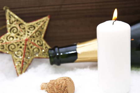用蜡烛和瓶香槟在雪上的快乐新的一年卡