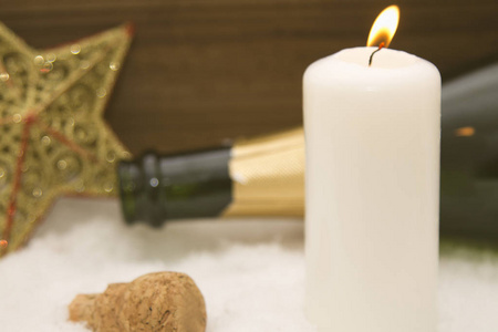 用蜡烛和瓶香槟在雪上的快乐新的一年卡