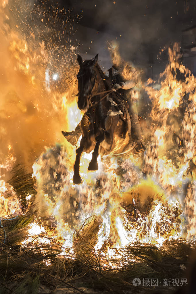 一个人骑他的马跳通过火