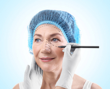 女性的脸，蓝色背景上绘制标记的外科医生。整形外科概念