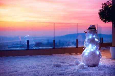 可爱的雪人，看着太阳落在屋顶露台上