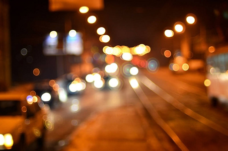 大城市的夜灯，模糊的夜大道，有博克的红绿灯和接近的汽车的前灯。