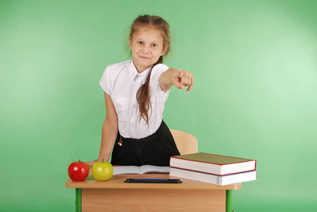 坐在一张桌子和点的学校制服的女孩