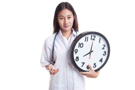 年轻的亚洲女医生微笑与时钟和丸